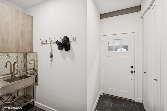 interior space with a sink and dark tile patterned flooring
