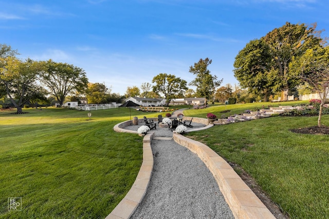 view of property's community with a lawn, a patio, and a fire pit