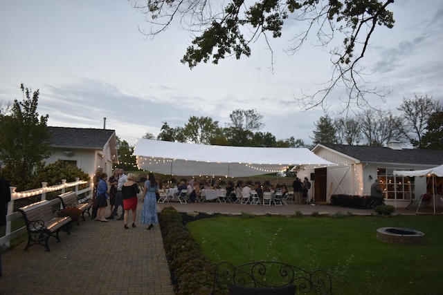 view of grassy yard with a patio and a fire pit