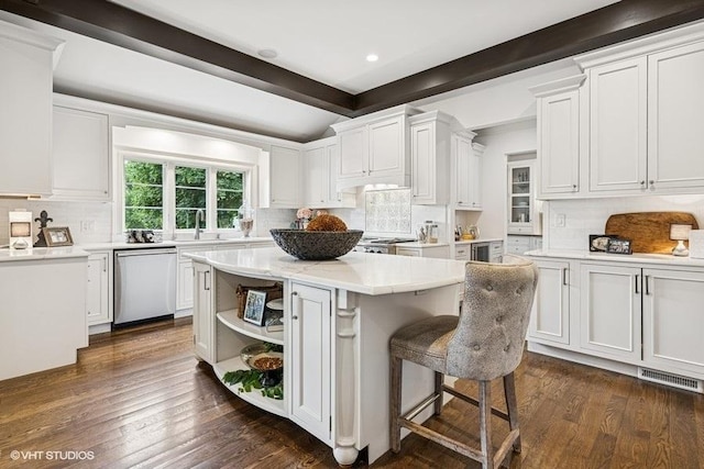 kitchen with stainless steel dishwasher, decorative backsplash, a center island, white cabinets, and beamed ceiling