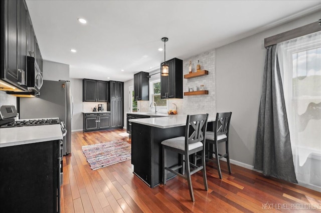 740 Lexington Ave, Saint Charles, IL 60174 - kitchen featuring dark cabinetry, a peninsula, tasteful backsplash, a breakfast bar area, and recessed lighting