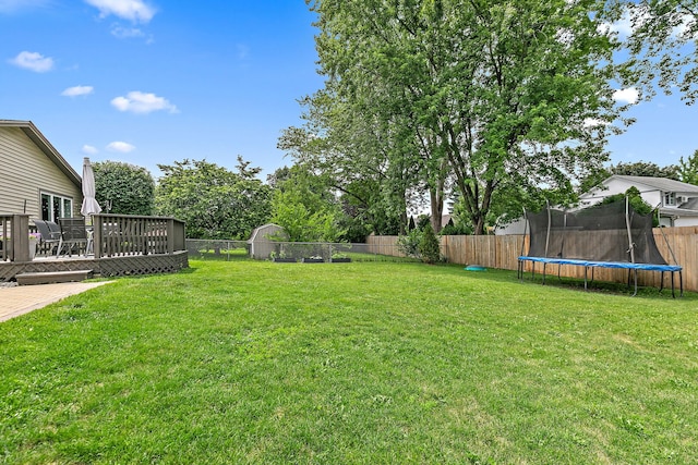 588 Arthur Dr, Cary, IL 60013 - fenced backyard featuring a trampoline and a deck