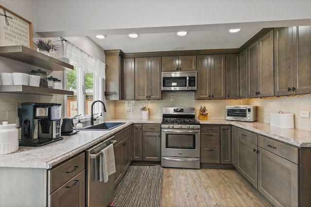 588 Arthur Dr, Cary, IL 60013 - kitchen with appliances with stainless steel finishes, open shelves, backsplash, light wood-style floors, and dark brown cabinetry