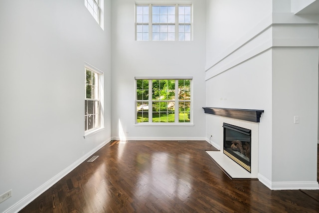 415 Bay Tree Cir, Vernon Hills, IL 60061 - unfurnished living room with a fireplace with flush hearth, a towering ceiling, and wood finished floors