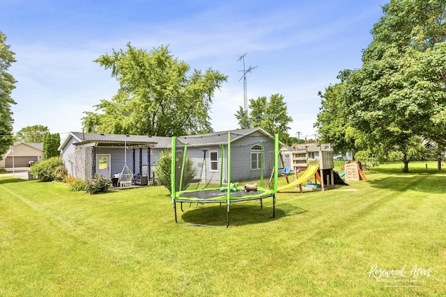 601 E Washington St, Ashkum, IL 60911 - rear view of property with a trampoline, a playground, and a lawn