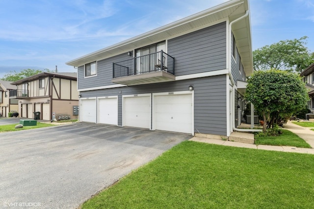 6265 Gold Cir Unit 6265, Hanover Park, IL 60133 - townhome / multi-family property with asphalt driveway, a balcony, an attached garage, and a front lawn
