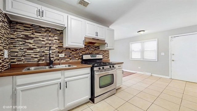 309 W 109th Pl, Chicago, IL 60628 - kitchen featuring stainless steel gas range oven, under cabinet range hood, decorative backsplash, light tile patterned floors, and white cabinets