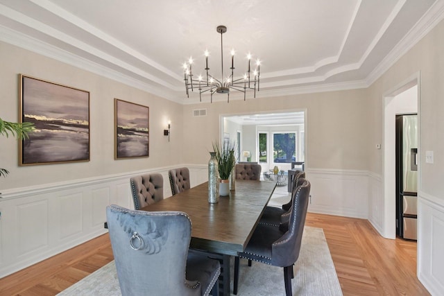 1123 Thackery Ln, Naperville, IL 60564 - dining space with a chandelier, a tray ceiling, light wood-type flooring, a wainscoted wall, and ornamental molding