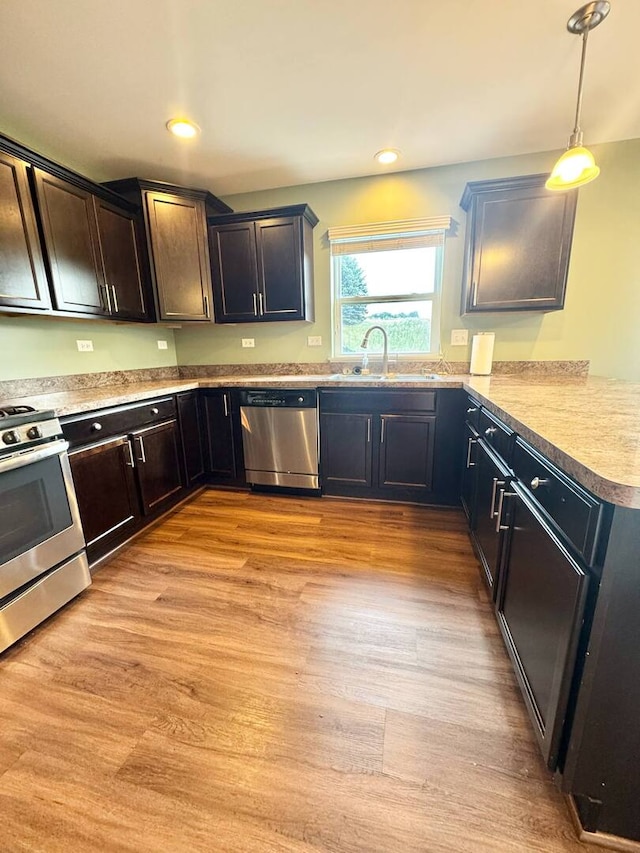 5 Boathouse Rd, Pingree Grove, IL 60140 - kitchen featuring appliances with stainless steel finishes, pendant lighting, light wood-style flooring, light countertops, and a peninsula
