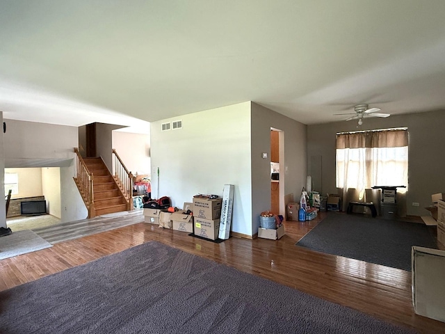 1907 Larkspur Dr, Plainfield, IL 60586 - living room featuring stairway, wood finished floors, a ceiling fan, and a fireplace
