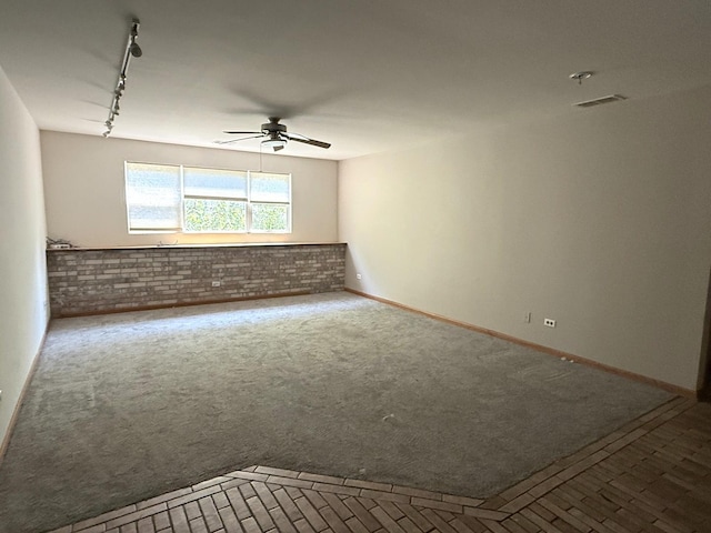 1907 Larkspur Dr, Plainfield, IL 60586 - carpeted empty room featuring ceiling fan, track lighting, and brick wall