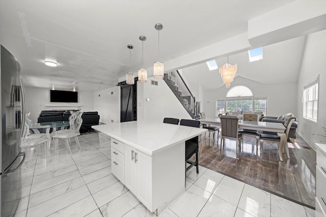 3032 Sandy Ridge Dr, Steger, IL 60475 - kitchen featuring open floor plan, light marble finish floors, a chandelier, stainless steel fridge, and vaulted ceiling