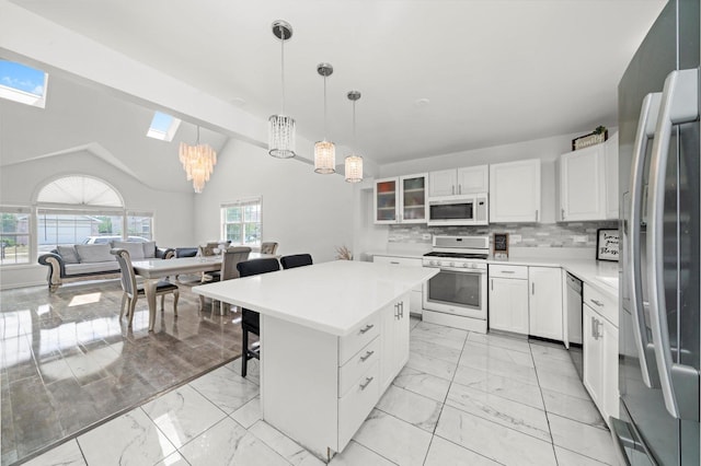 3032 Sandy Ridge Dr, Steger, IL 60475 - kitchen with white appliances, light marble finish flooring, a skylight, a breakfast bar area, and vaulted ceiling