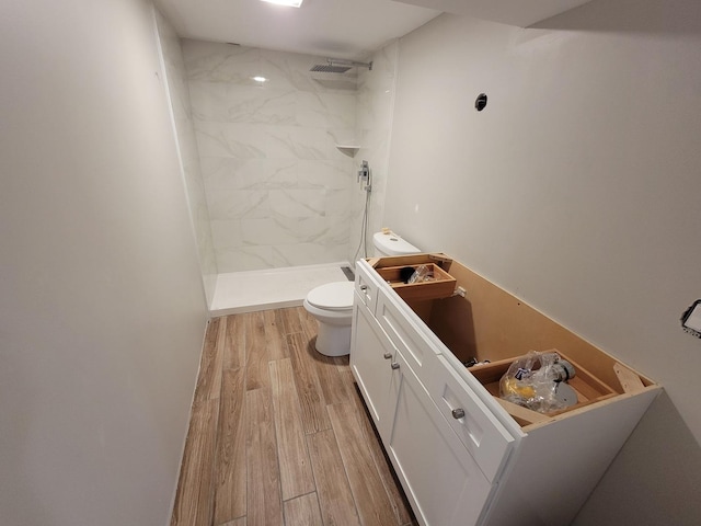 6308 W Cornelia Ave, Chicago, IL 60634 - bathroom featuring a tile shower, wood finished floors, and vanity