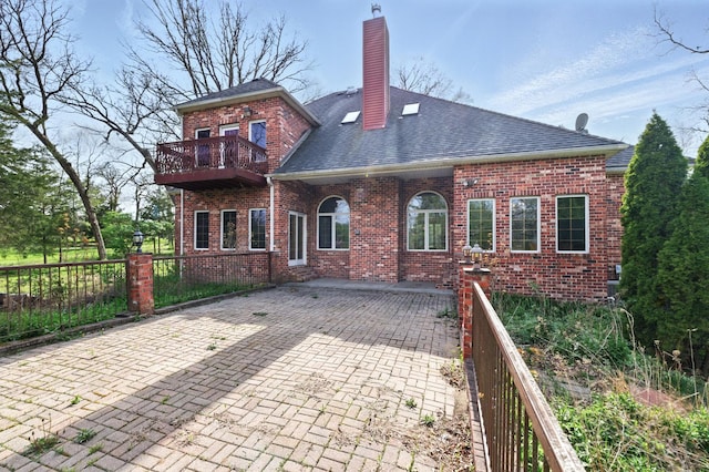 3664 E 2619th Rd, Sheridan, IL 60551 - back of property with brick siding, roof with shingles, a chimney, a balcony, and a patio area