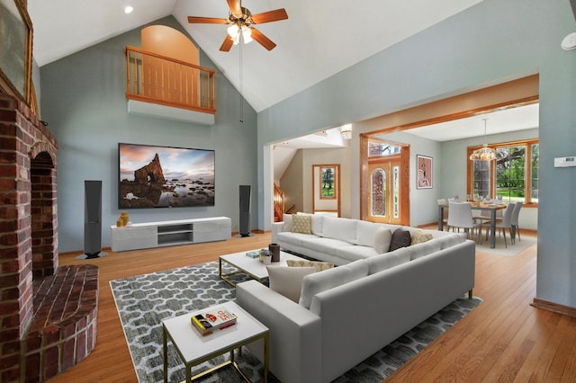 3664 E 2619th Rd, Sheridan, IL 60551 - living room featuring wood finished floors, a ceiling fan, high vaulted ceiling, a chandelier, and a brick fireplace