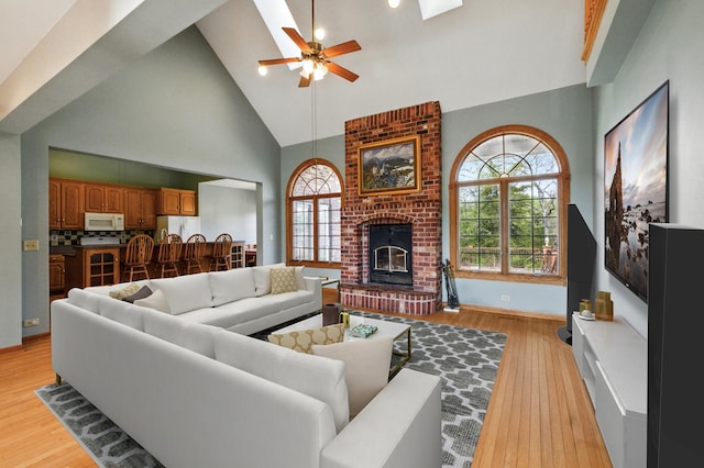 3664 E 2619th Rd, Sheridan, IL 60551 - living room featuring high vaulted ceiling, ceiling fan, light wood-style flooring, plenty of natural light, and a fireplace