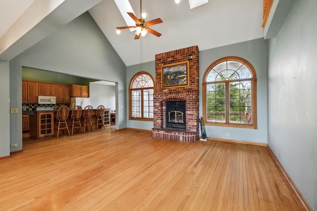 3664 E 2619th Rd, Sheridan, IL 60551 - living room featuring high vaulted ceiling, light wood-type flooring, ceiling fan, healthy amount of natural light, and a fireplace