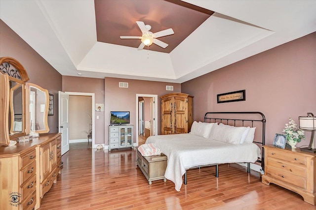24155 S Blackhawk Ln, Manhattan, IL 60442 - bedroom featuring a raised ceiling, light wood-type flooring, and a ceiling fan