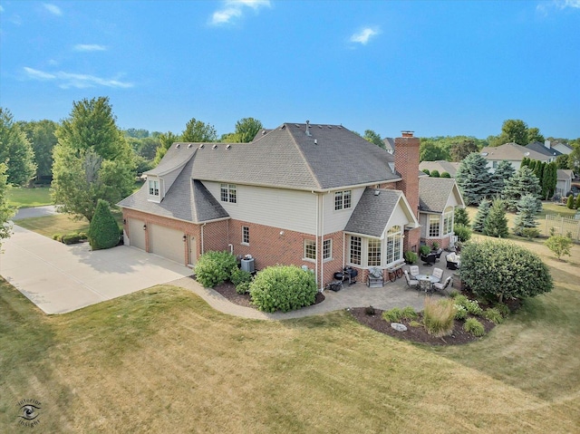 24155 S Blackhawk Ln, Manhattan, IL 60442 - back of house featuring a yard, brick siding, concrete driveway, a patio area, and entry steps