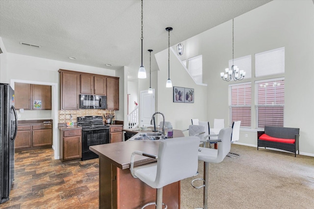 412 Doisy Ln, Champaign, IL 61822 - kitchen featuring black appliances, a chandelier, tasteful backsplash, pendant lighting, and a textured ceiling