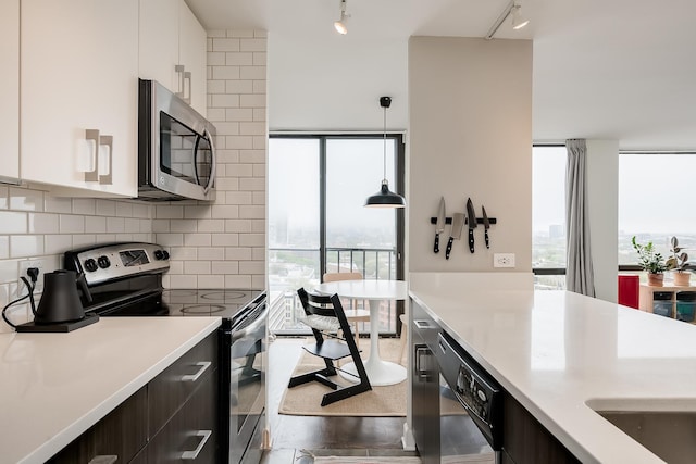 345 W Fullerton Pkwy Unit 1706, Chicago, IL 60614 - kitchen featuring stainless steel appliances, rail lighting, tasteful backsplash, and light countertops