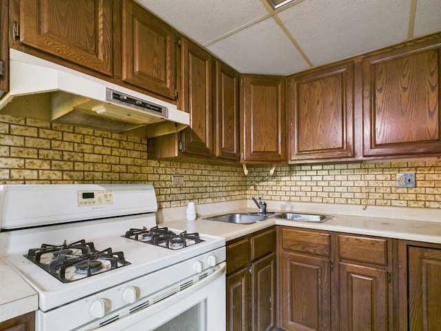 2404 Sigwalt St, Rolling Meadows, IL 60008 - kitchen featuring white gas range oven, light countertops, under cabinet range hood, and tasteful backsplash