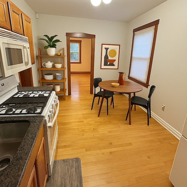 3514 N Lawndale Ave Unit 2, Chicago, IL 60618 - kitchen featuring white appliances, brown cabinets, light wood finished floors, open shelves, and dark stone countertops