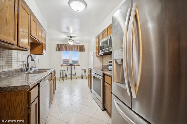 9377 Landings Ln Unit 502, Des Plaines, IL 60016 - kitchen featuring appliances with stainless steel finishes, backsplash, brown cabinets, and a ceiling fan