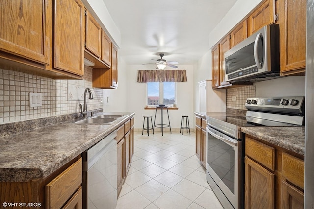 9377 Landings Ln Unit 502, Des Plaines, IL 60016 - kitchen with stainless steel appliances, decorative backsplash, ceiling fan, and brown cabinets