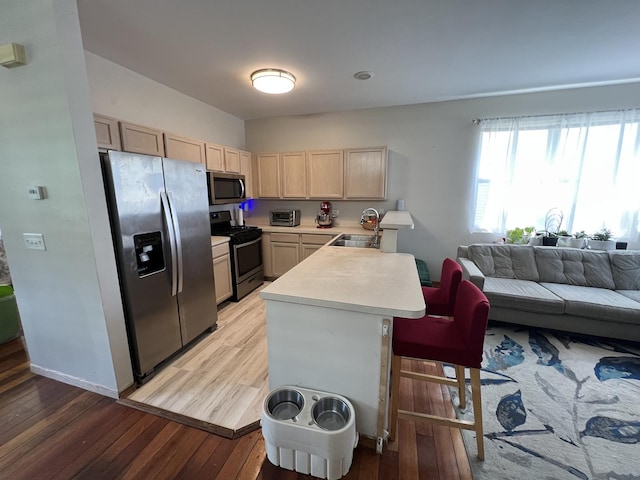 163 Mountain Laurel Ct, Romeoville, IL 60446 - kitchen featuring appliances with stainless steel finishes, light brown cabinets, light countertops, a peninsula, and open floor plan