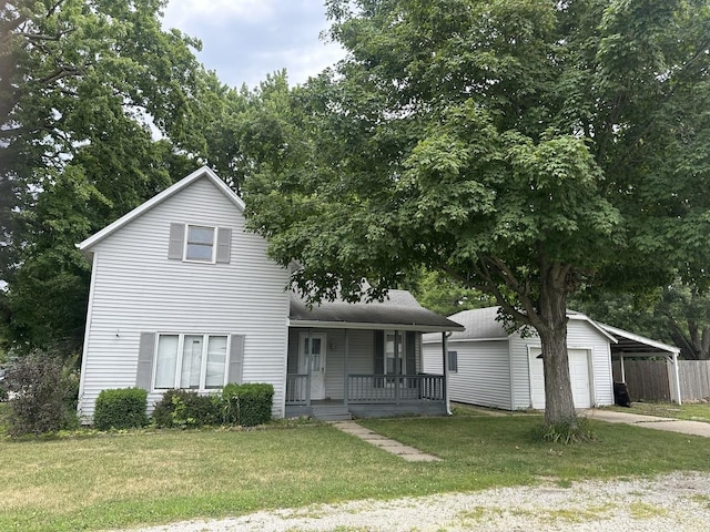 201 E N St, Saybrook, IL 61770 - traditional home featuring covered porch, a front lawn, a garage, driveway, and an outdoor structure