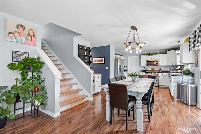 243 Johnson St, Hampshire, IL 60140 - dining space with stairs, wood finished floors, and a chandelier