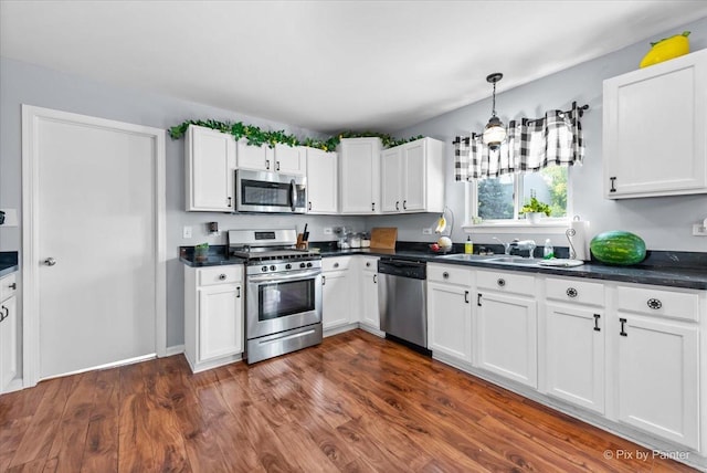 243 Johnson St, Hampshire, IL 60140 - kitchen with appliances with stainless steel finishes, dark countertops, white cabinetry, and dark wood-type flooring