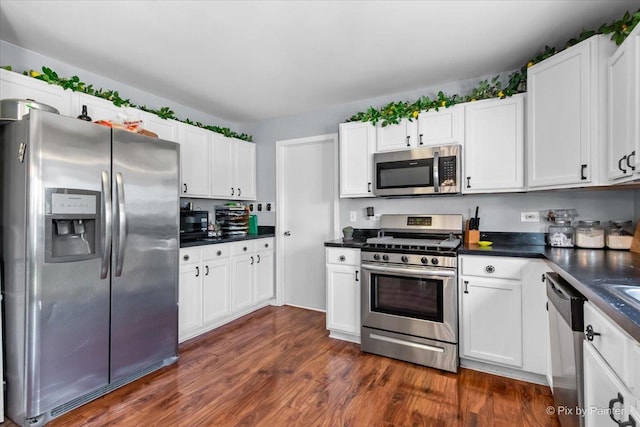 243 Johnson St, Hampshire, IL 60140 - kitchen featuring appliances with stainless steel finishes, dark countertops, white cabinets, and dark wood finished floors