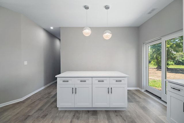 121 Pine St, Buckingham, IL 60917 - kitchen with light countertops, light wood-style floors, white cabinets, and pendant lighting