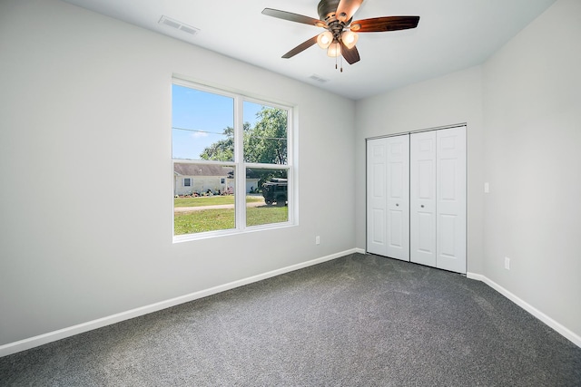 121 Pine St, Buckingham, IL 60917 - unfurnished bedroom featuring dark carpet, a ceiling fan, and a closet