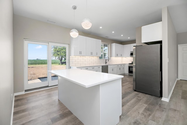 121 Pine St, Buckingham, IL 60917 - kitchen with appliances with stainless steel finishes, light countertops, backsplash, white cabinetry, and light wood-style flooring