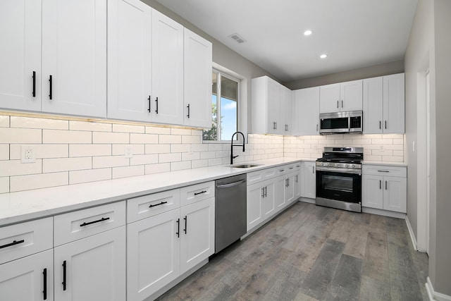121 Pine St, Buckingham, IL 60917 - kitchen with stainless steel appliances, wood finished floors, recessed lighting, white cabinetry, and tasteful backsplash