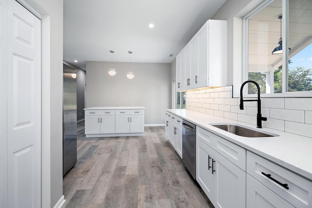 121 Pine St, Buckingham, IL 60917 - kitchen with stainless steel appliances, light wood-type flooring, white cabinetry, decorative backsplash, and decorative light fixtures
