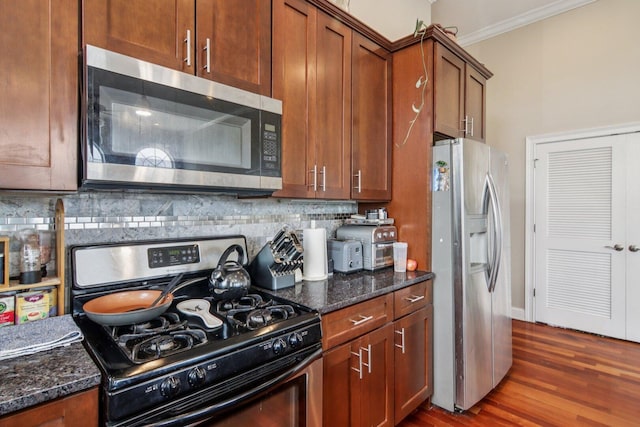 3234 N California St Unit 3S, Chicago, IL 60618 - kitchen with stainless steel appliances, decorative backsplash, dark wood finished floors, crown molding, and dark stone counters