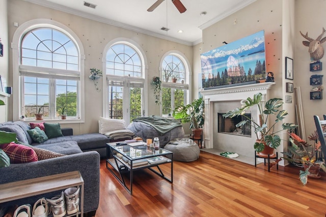 3234 N California St Unit 3S, Chicago, IL 60618 - living room featuring wood finished floors, a ceiling fan, ornamental molding, a fireplace, and a towering ceiling