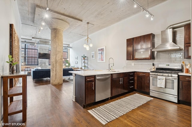 17 N Loomis St Unit 1C, Chicago, IL 60607 - kitchen with stainless steel appliances, wall chimney range hood, track lighting, light countertops, and dark wood finished floors