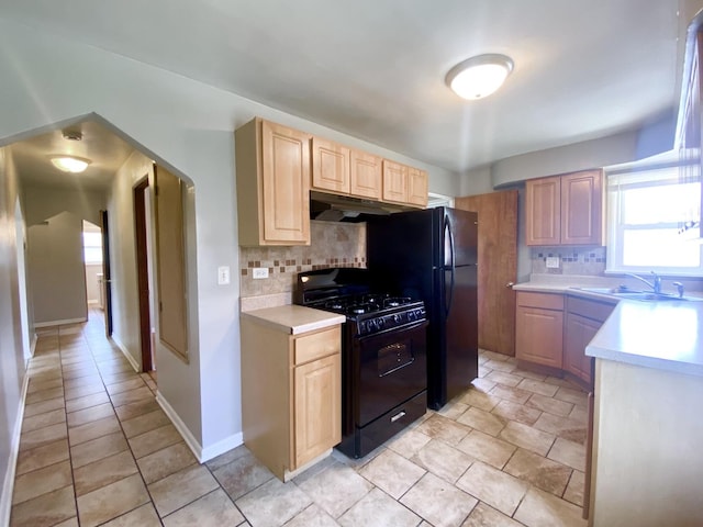 518 156th Pl, Calumet City, IL 60409 - kitchen with black range with gas stovetop, under cabinet range hood, light countertops, and tasteful backsplash