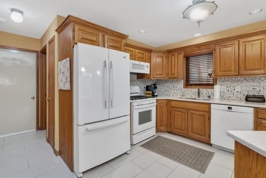 16620 Grants Trl, Orland Park, IL 60467 - kitchen with white appliances, light countertops, tasteful backsplash, brown cabinets, and recessed lighting