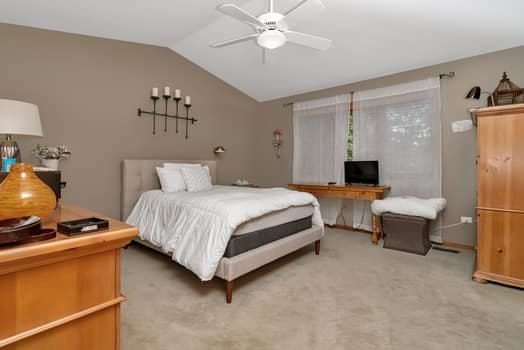 16620 Grants Trl, Orland Park, IL 60467 - bedroom with lofted ceiling, light carpet, and ceiling fan