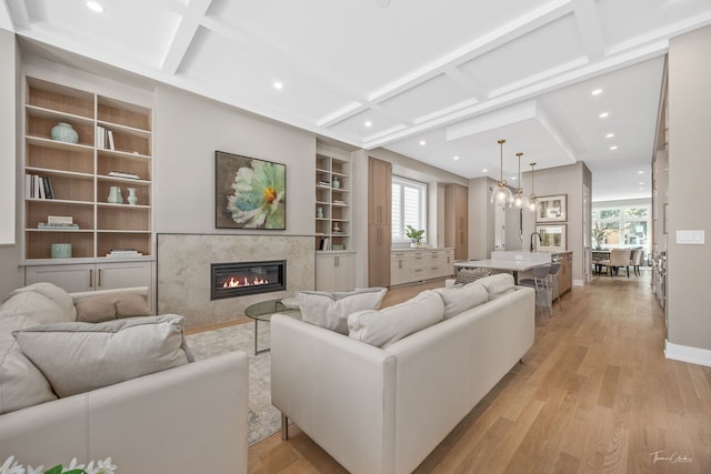 1642 W Wolfram St, Chicago, IL 60657 - living room featuring built in shelves, light wood-style floors, coffered ceiling, a premium fireplace, and recessed lighting