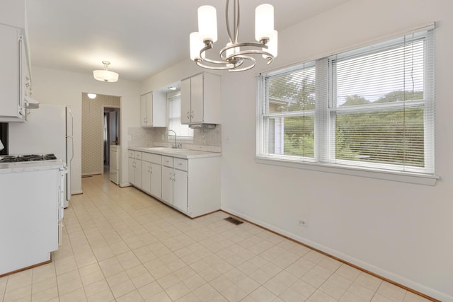 1108 Lancaster Ave, Elk Grove Village, IL 60007 - kitchen featuring light countertops, a chandelier, washer / clothes dryer, and white cabinetry