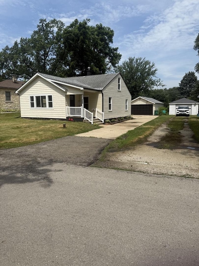 309 SE Circle Dr, Joliet, IL 60433 - view of front of home featuring covered porch, a detached garage, an outbuilding, and a front yard