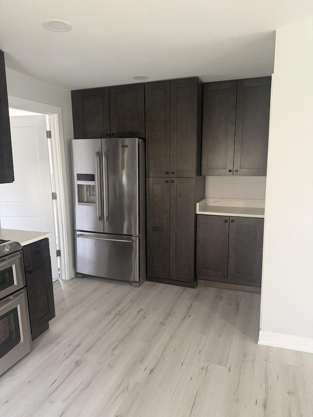 309 SE Circle Dr, Joliet, IL 60433 - kitchen with high end fridge, light wood-style floors, stove, and light countertops